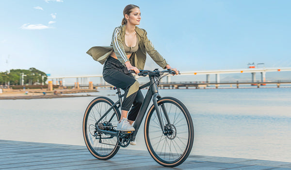 Woman riding electric bike by lake